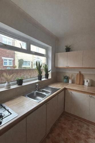 a kitchen with a sink and a window at St Joseph's Guest House in Southampton