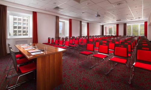
a room with chairs, tables, and a red carpet at Ibis Nizhniy Novgorod in Nizhny Novgorod
