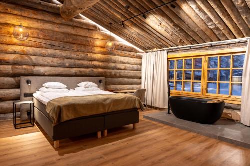 a bedroom with a bed and a bath tub at Saariselkä Kelo Lodge in Saariselka