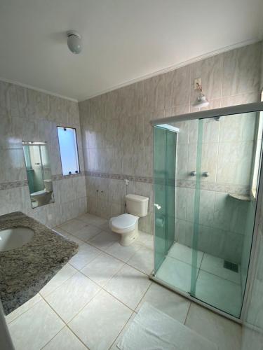 a bathroom with a glass shower and a toilet at HervaDoce in Rio das Ostras