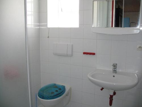 a white bathroom with a sink and a toilet at Meeresbrise in Loperhet
