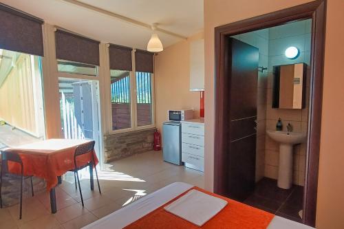 a bathroom with a table and a kitchen with a sink at Nestor Apartments in Chrysi Ammoudia