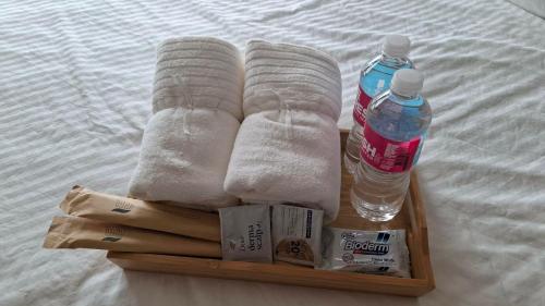 a wooden tray with a bottle of water and towels at Beloved's Homestay in Iruhin