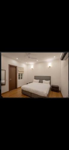 a bedroom with a bed with white sheets and pillows at The carmine house-Private 4 BHk luxury retreat in sector 132, Noida in Noida