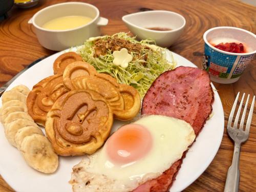 a plate of food with an egg and meat and a salad at 民泊&guest house NOOK NOOK ディズニーまで無料お送り Free drop-off to Tokyo Disney in Tokyo