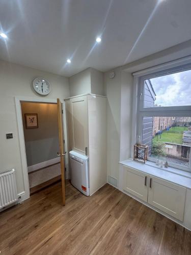 an empty room with a window and a sink and a refrigerator at The Coastal Haven, Broughty Ferry in Dundee