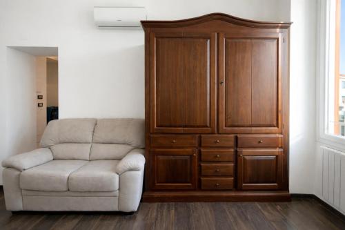 a living room with a chair and a large cabinet at Casa Danilo Sanremo Centro - a 100m dalla Spiaggia in Sanremo