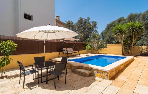 a patio with a table and an umbrella and a pool at Calamari 7 in Portocolom