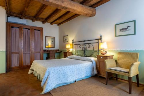 a bedroom with a bed and a chair at Musella Winery & Relais in San Martino Buon Albergo