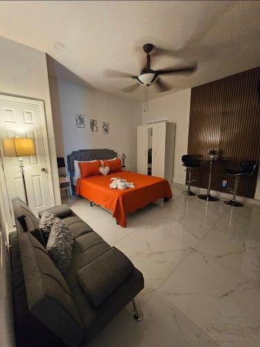 a bedroom with an orange bed and a couch at Romantic Suite in Tampa