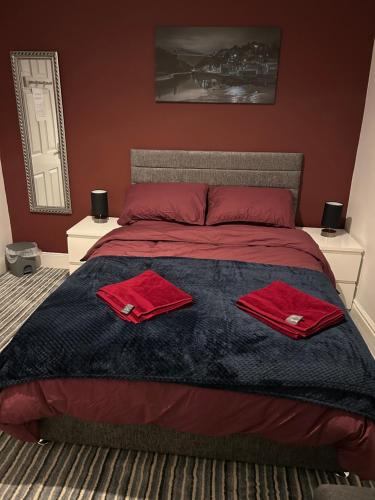 a bedroom with a bed with red towels on it at Barratt Street En-Suite Rooms in Bristol
