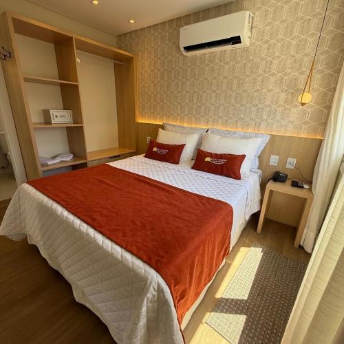 a bedroom with a large bed with red pillows at CAPÃO Da CANOA MAR HOTEL in Capão da Canoa