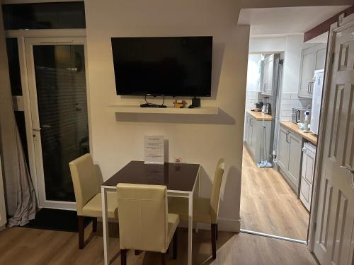 a dining room with a table and a television on a wall at Barratt Street En-Suite Rooms in Bristol