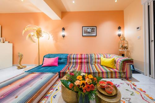 a living room with a couch and colorful pillows at Suites Romantiques avec Jacuzzi - Marne-La-Vallée - Le Jardin De Vos Secrets in Mouroux