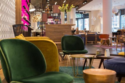 a store with green chairs and tables and a restaurant at Mercure Krakow Stare Miasto in Kraków