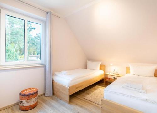 a small room with two beds and a window at Haus Hanse in Korswandt