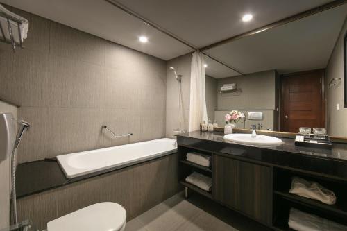 a bathroom with a tub and a sink and a toilet at Sora Hotel Hanoi in Hanoi