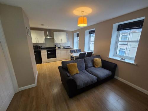 a living room with a couch and a kitchen at 4b Smart Apartments in Newark-on-Trent
