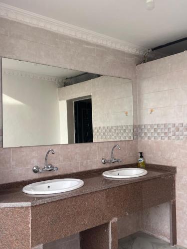 a bathroom with two sinks and a large mirror at Local experience in El Quweira