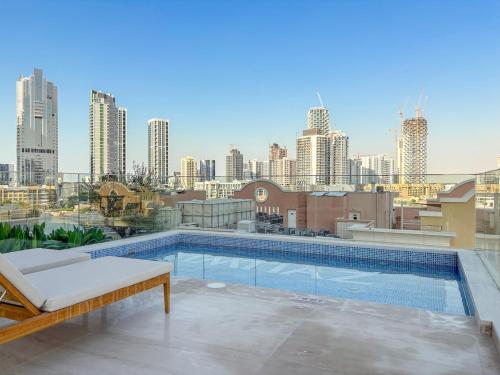FIRST CLASS 1BR Pearl House Elegance في دبي: مسبح على سطح مبنى يطل على أفق المدينة