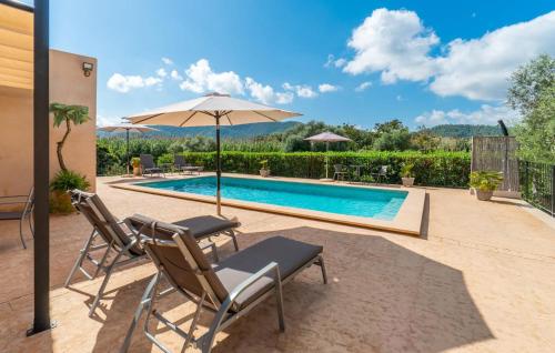 a patio with two chairs and an umbrella next to a pool at Clonenell in Canyamel