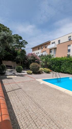Appartement T2 في تولوز: مسبح فارغ أمام مبنى