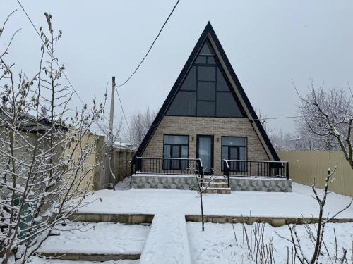 a house with a thatched roof in the snow at Boss House in Quba