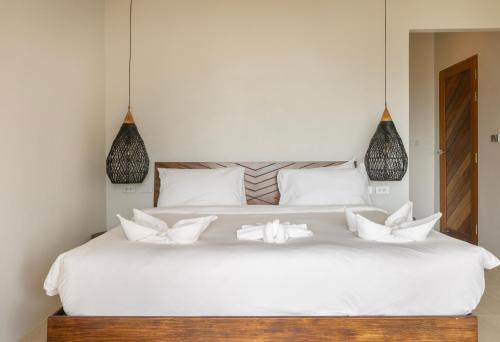 a bedroom with a white bed with white pillows at Ocean Villa in Ko Phangan