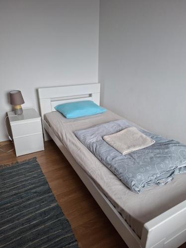 a bedroom with a bed with a blue pillow and a night stand at FLAMANITA APARTMENTS in Skopje