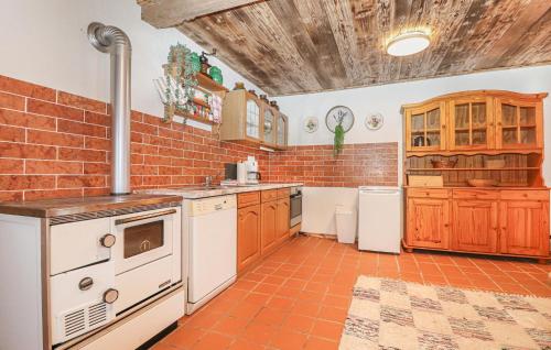 a kitchen with white appliances and a brick wall at Charmantes Ferienhaus in Schwendt