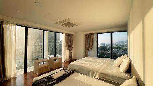 a hotel room with two beds and large windows at Sunrise Gurney Georgetwon in George Town
