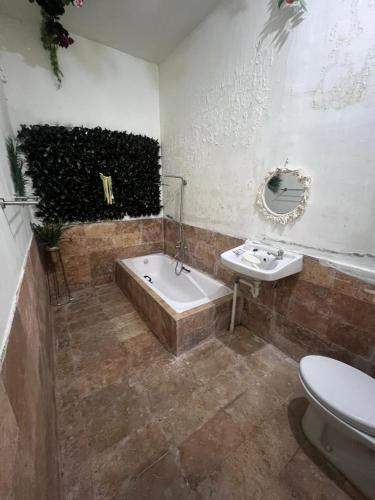 a bathroom with a bath tub and a sink at Gandasari Homestay Banyuwangi in Dadapan