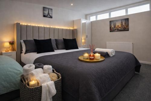 a bedroom with a large bed with candles on it at Iron House - Sleeps 11 - For Contractors & Families - Free Parking - Near Excel , Canary Wharf, O2, City AirPort & GreenWich in London
