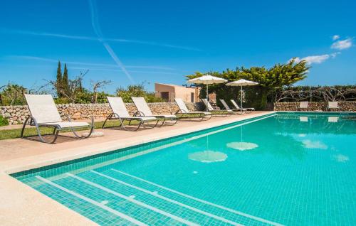 a swimming pool with chairs and umbrellas next to it at Son Capellot Dos in Felanitx
