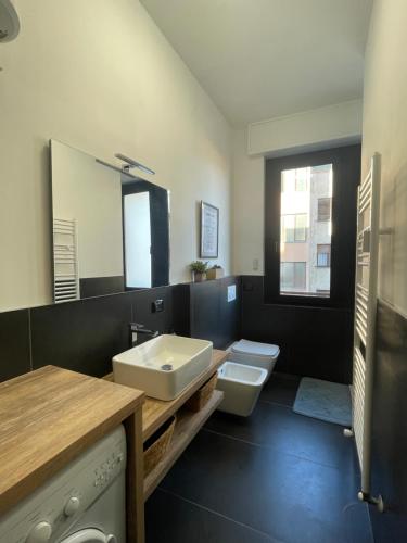 a bathroom with a sink and a toilet and a mirror at Appartamento con vista su Brunate in Olgiate Comasco