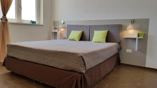 a bedroom with a large bed with two lime green pillows at Case Vacanza Marzano in Monopoli