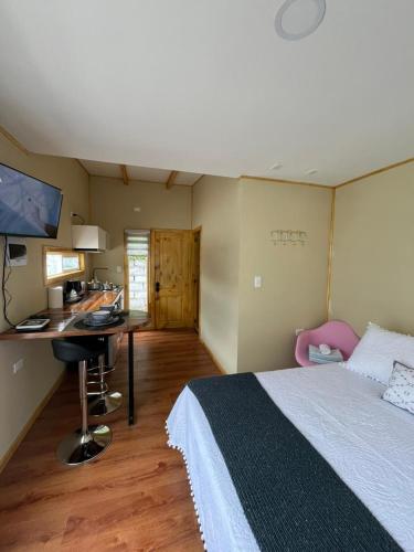a bedroom with a bed and a desk with a computer at Cabañas Varas in Osorno