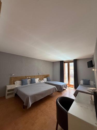 a bedroom with two beds and a couch at Hotel Acebo Plaza Mayor in Jaca