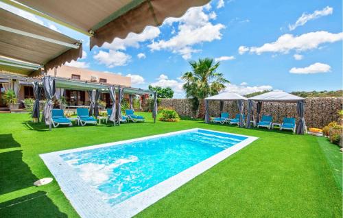 a swimming pool in a yard with chairs and umbrellas at Villa Son Gat Mallorca in Montuiri