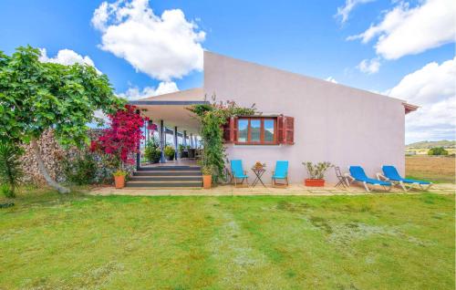 a white house with blue chairs and a yard at Villa Son Gat Mallorca in Montuiri