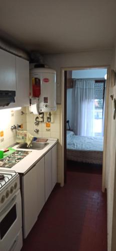 a kitchen with a stove and a room with a bed at San Berardo Brava 3 sobre costanera in San Bernardo
