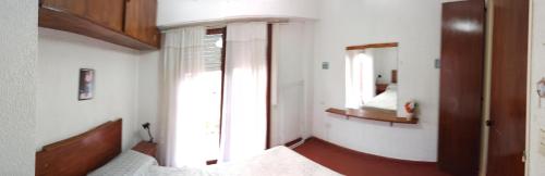 a bedroom with a bed and a window and a mirror at San Berardo Brava 3 sobre costanera in San Bernardo