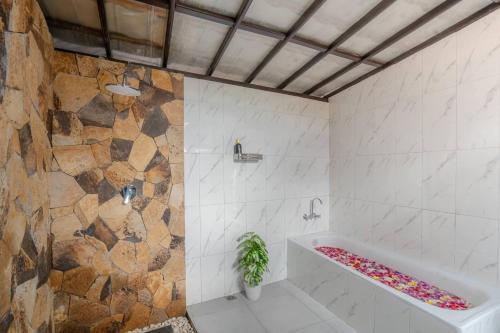 a bathroom with a tub and a plant in it at Gistari Inn & Restaurant in Seraya