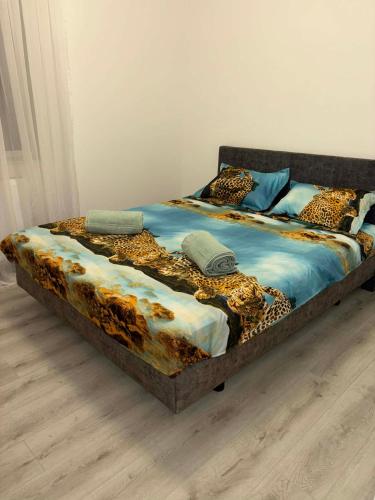 a bed with a leopard print comforter and pillows at La Sibip in Târgu Neamț