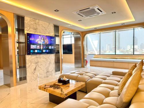 a living room with a couch and a tv at The Prestige Living Bangkok at Sathorn-Chan in Bangkok