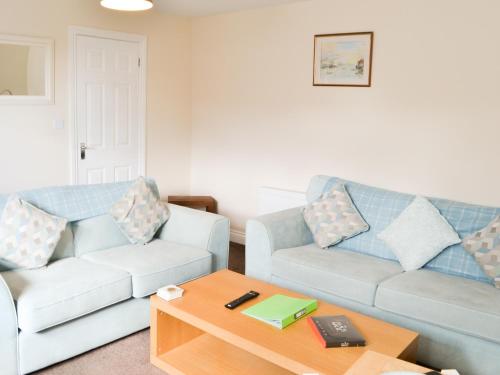 a living room with two couches and a coffee table at Cygnet Cottage - Uk43546 in Belford
