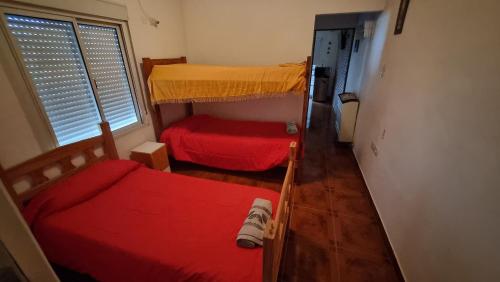 a small room with two bunk beds and a window at Arcoiris in General Acha