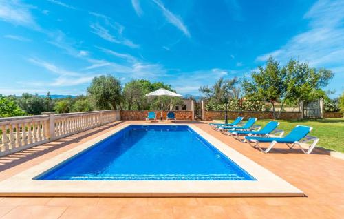 a swimming pool with blue chairs and a fence at Sa Vileta in Sencelles