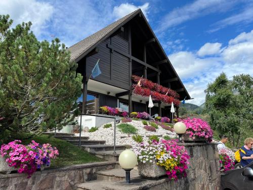 a house with flowers in front of it at Hotel Panorama in Cavalese
