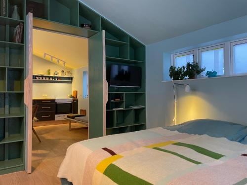 a bedroom with green book shelves and a bed at Agerdal - dejligt hus midt i mark og have in Nykøbing Mors